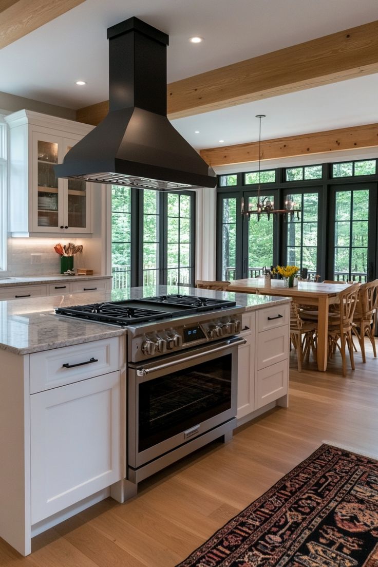 a kitchen with an oven, stove and dining room table in the backround