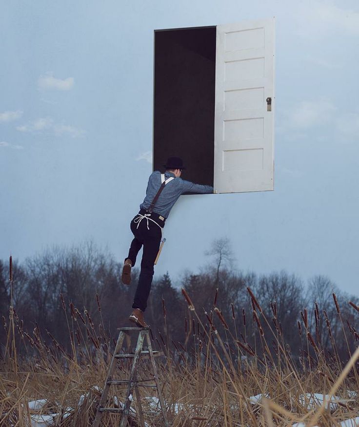 a man climbing up the side of a building on top of a ladder in front of a window