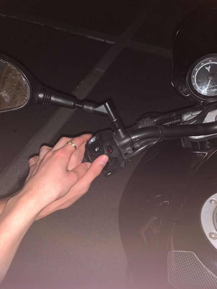 a person is touching the handlebars on a motorcycle