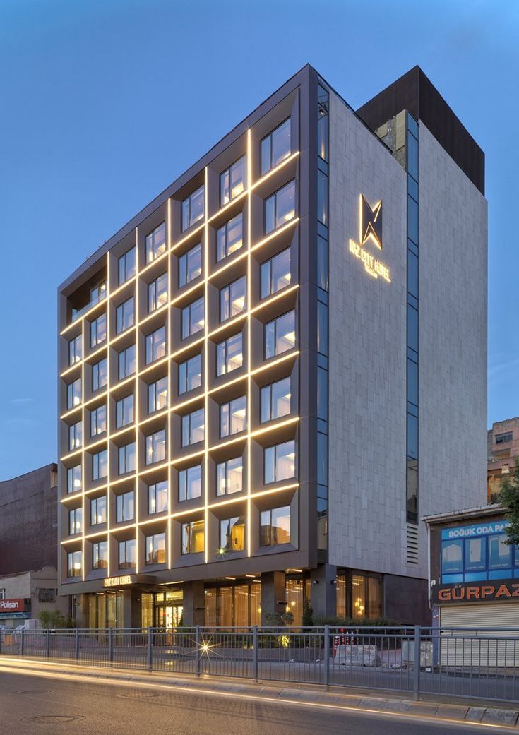 a large building with lots of windows on the front and side of it at night