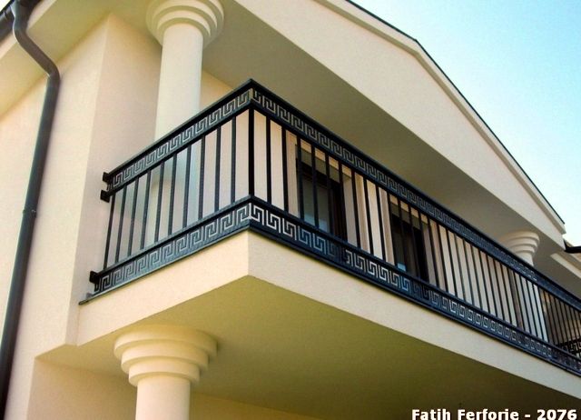 a white building with black balconies and balcony railings