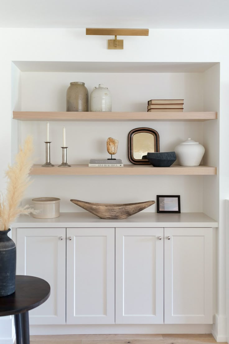 the shelves in this living room are filled with vases and other items