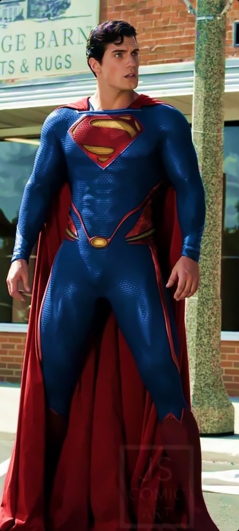 a man dressed as superman standing in the street