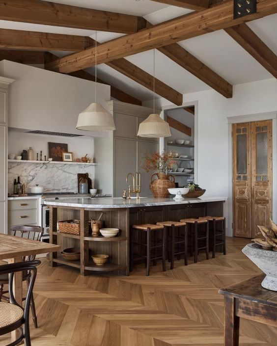 an open kitchen and dining room with wooden beams on the ceiling, hardwood flooring