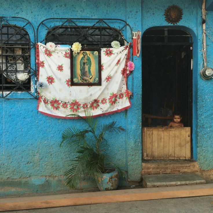 a blue building with a white and red banner hanging from it's side window