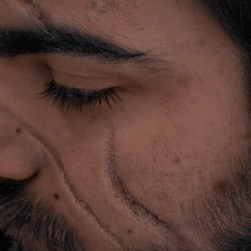 a close up of a man's face with his eyes closed