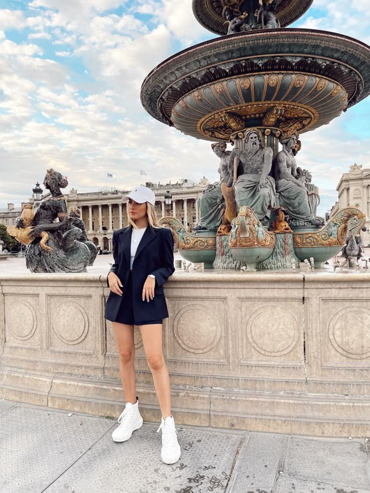 a woman standing in front of a fountain