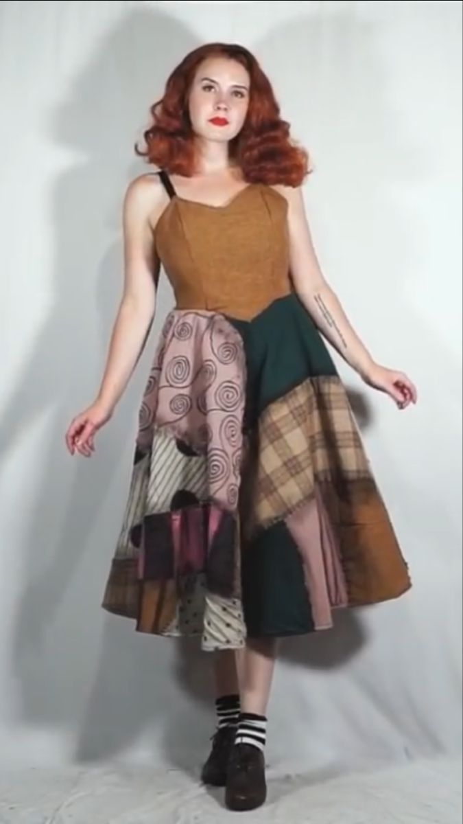 a woman with red hair is wearing a dress made out of different colors and patterns