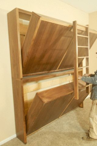 a man standing in front of a wooden bed