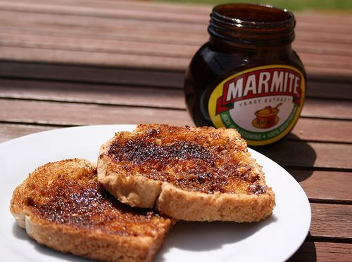 two pieces of toast sit on a plate next to a jar of marmalade