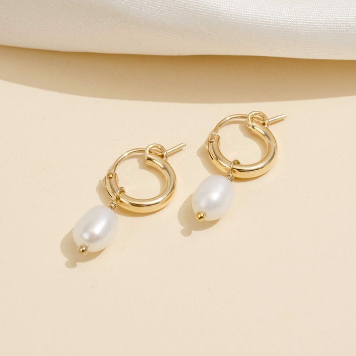 Elevate your hoop earring game with these exquisite dainty Pearl Hoops, brought to you by none other than Katie Dean Jewelry and proudly made in America. These gorgeous hoops are designed to take your love for hoop earrings to the next level, featuring a delicate pearl charm that exudes sophistication and elegance. Crafted with the highest quality demi-fine materials, the hoop is 14k gold filled and nickel-free, making it safe for even the most sensitive earlobes. With a perfect blend of style and comfort, these dainty pearl hoops are the ideal addition to any jewelry collection. So why wait? Treat yourself to these stunning earrings and get ready to turn heads wherever you go! Everyday Metal Hoop Earrings With Pearl Drop, Everyday Hoop Earrings With Pearl Drop, Dainty Metal Hoop Earrings, Small Hoop Pearl Earrings For Everyday, Small Hoop Metal Pearl Earrings, Everyday Hoop Pearl Earrings With Ear Wire, Everyday Pearl Hoop Earrings With Ear Wire, Everyday Small Hoop Pearl Earrings, Dainty Hoop Huggie Earrings