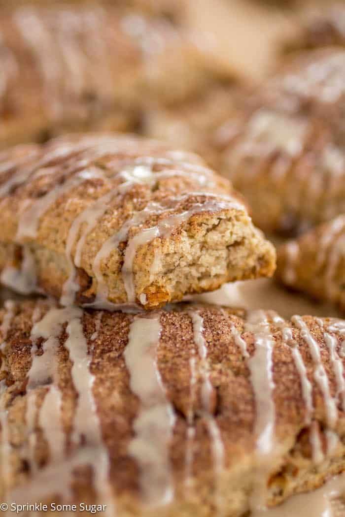 cinnamon sugar scones with icing on a table in front of other pastries