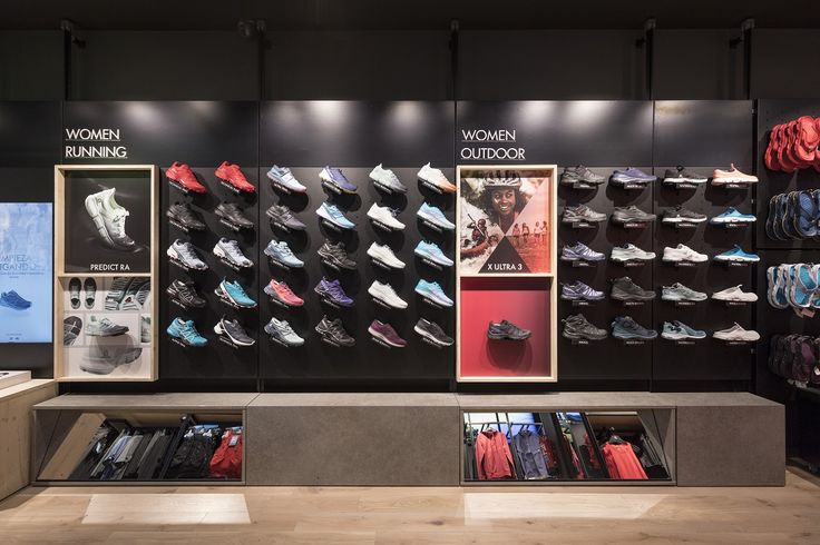 the inside of a clothing store with shoes on display