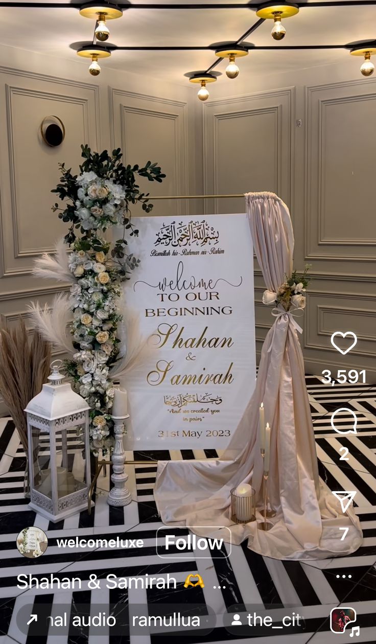 the wedding sign is on display in front of an ornate white backdrop with flowers and greenery