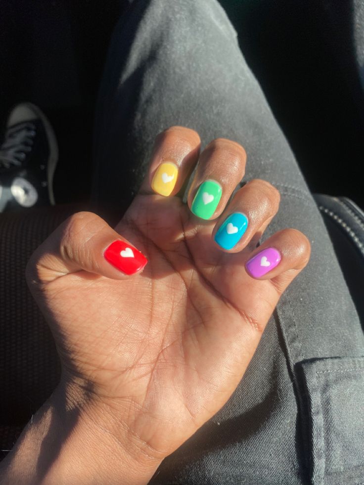 colorful rainbow pride nails with little white hearts in the middle Pride Short Nails, Simple Pride Nail, Rainbow Nails Short, Rainbow Heart Nails, Rainbow Short Nails, Subtle Rainbow Nails, Pansexual Nails, Pride Nails Short, Subtle Pride Nails