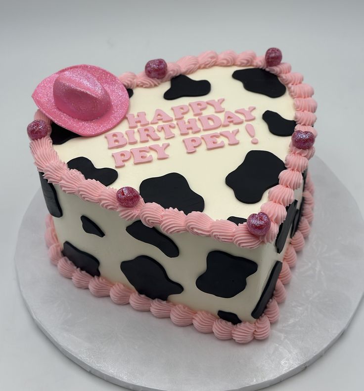 a birthday cake decorated with pink and black cow print