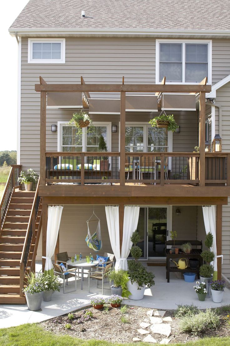 a deck with curtains on it and some plants