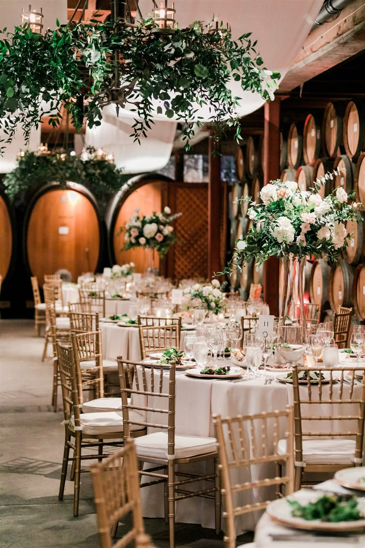 the tables are set up with wine barrels in the background