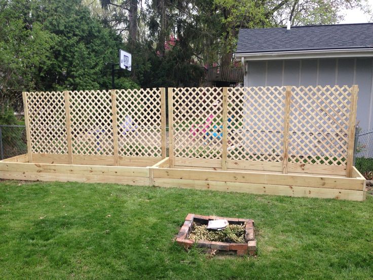 a backyard area with a wooden fence and green grass