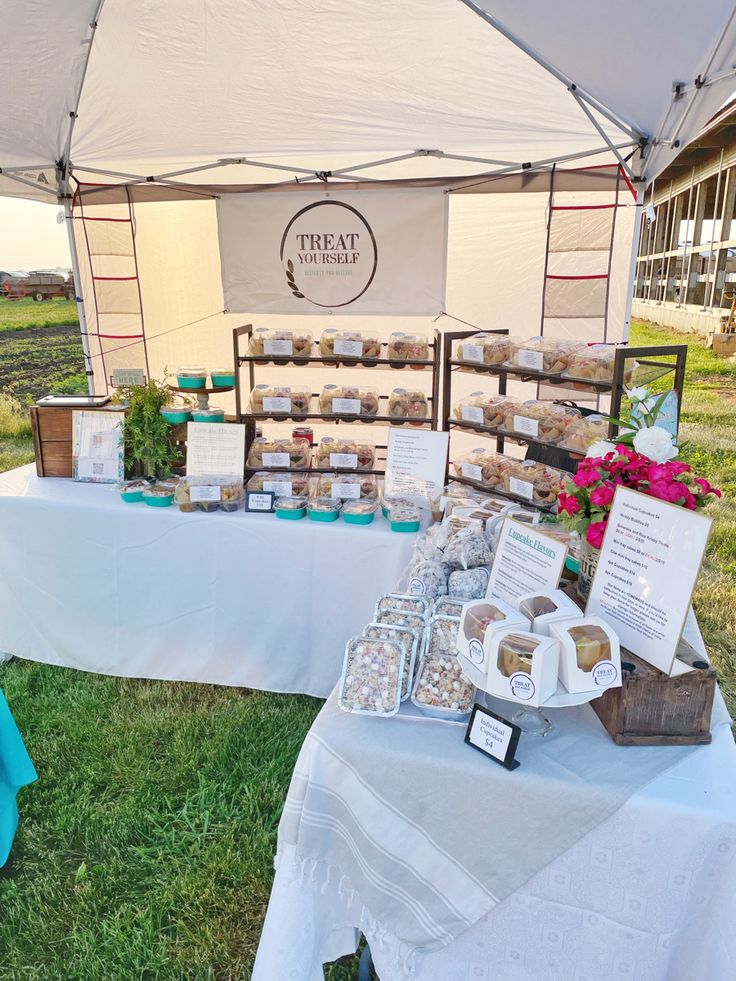 a table that has some food on it and is set up in front of a tent