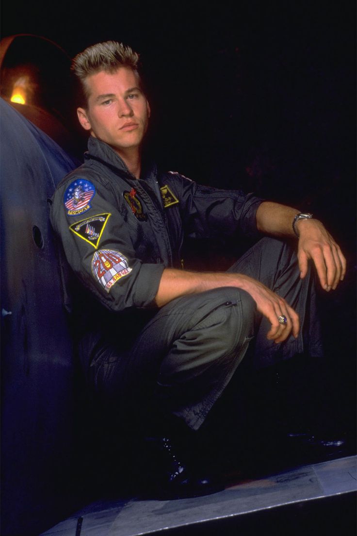 a man in an air force pilot's uniform sitting on the back of a plane