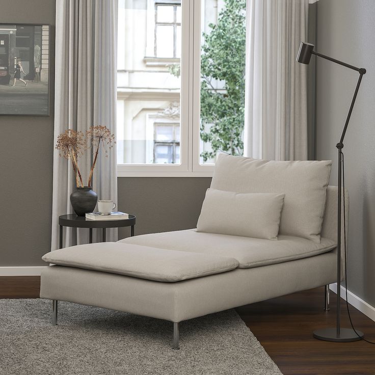 a white chaise lounge chair sitting in front of a window