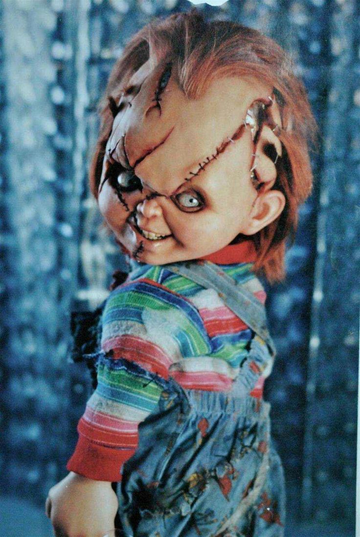 an old photo of a creepy doll with red hair and big eyes wearing overalls