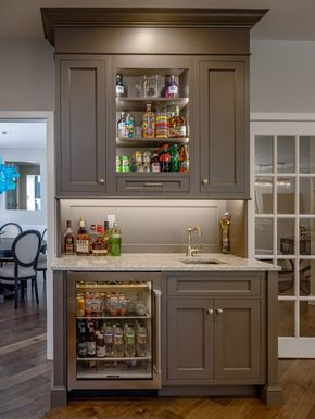 a kitchen with gray cabinets and white counter tops