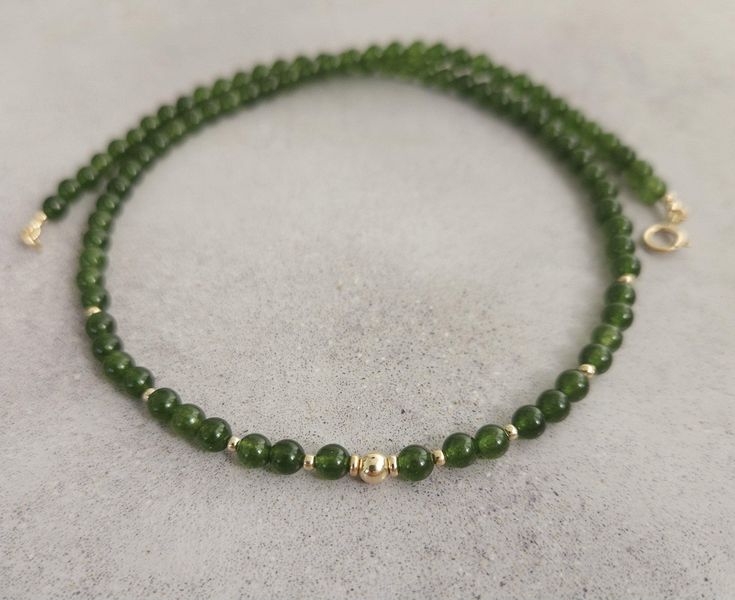 Green jade gemstone beaded chocker,every day necklace Made with smooth 4mm jade beads and 14k solid yellow gold beads and clasp. Please select your prefered length before checkout This minimalist necklace can be worn short as a chocker or longer alone or layered with other necklaces  Measures: 💚4mm  jade smooth beads 💚2mm and 4mm solid gold beads 💚6mm spring ring clasp 100% 14k solid gold hallmarked on clasp Minimalist Jade Gemstone Jewelry, Jade Necklaces With Round Beads For Gifts, Jade Necklace With Round Beads For Gifts, Jade Bead Necklace For Gifts, Minimalist Jade Jewelry For May Birthstone, Classic Jade Jewelry For Gift, Classic Jade Jewelry As Gift, Dainty Jade Gemstone Jewelry, Spiritual Jewelry With Tiny Round Beads