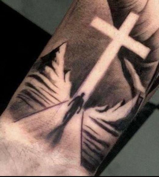 a person with a cross tattoo on their arm