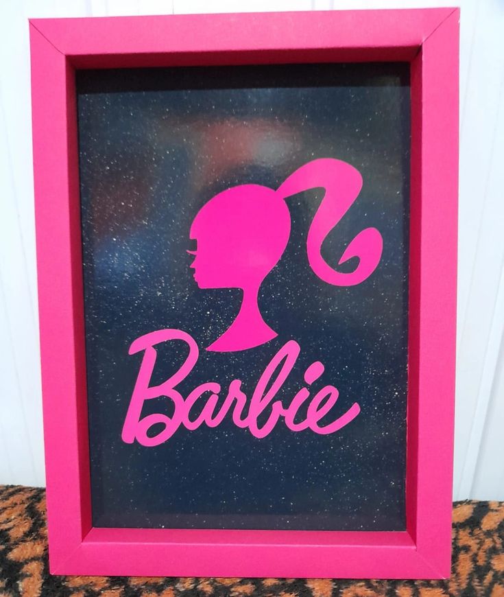 a pink frame with the word barbie on it and a silhouette of a woman's head