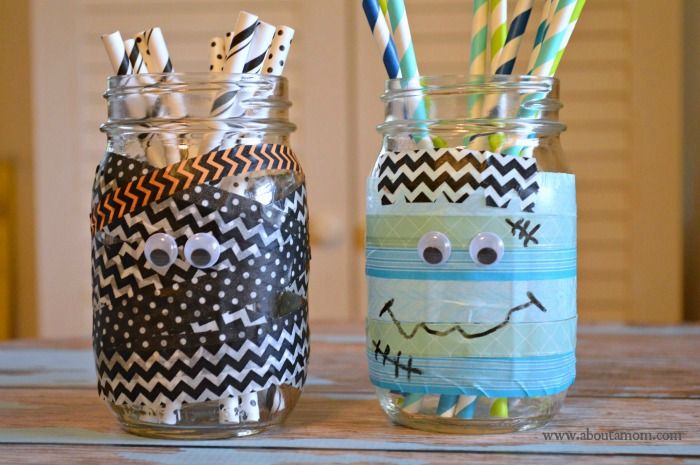 two mason jars with toothbrushes in them decorated to look like monsters and smiling faces