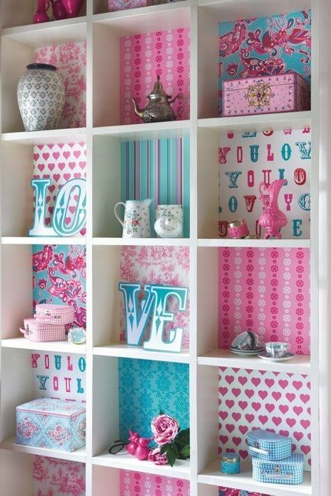 a book shelf filled with lots of pink and blue items