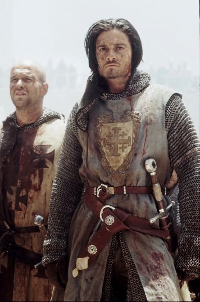 two men dressed in medieval armor standing next to each other with blood all over them