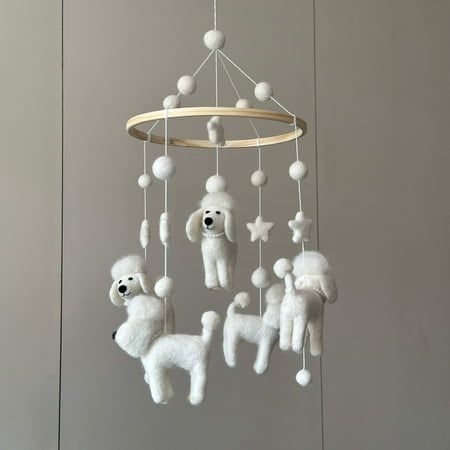 a mobile with poodles and balls hanging from it