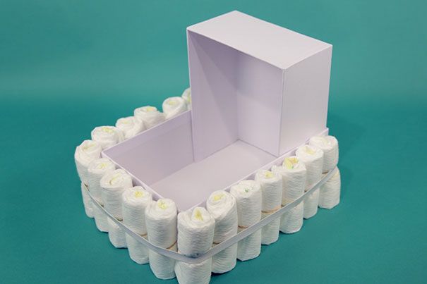 an open box with white candles inside on a blue background in the shape of a toothbrush holder