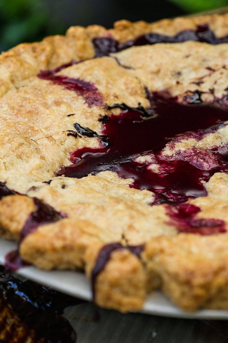 a blueberry pie is on a white plate