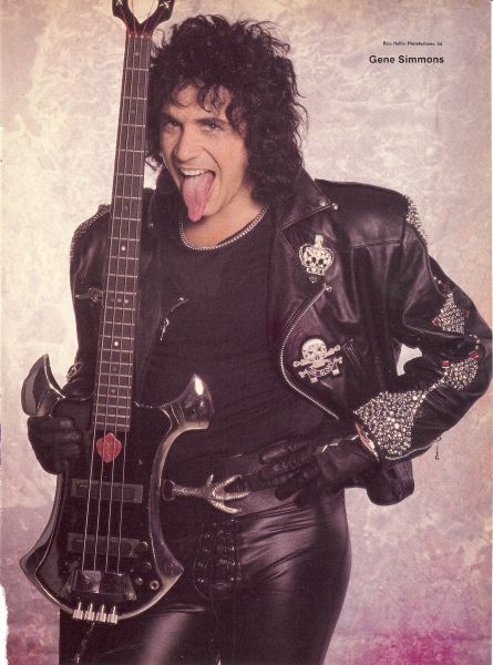 a man in black leathers is holding a guitar and making a funny face with his mouth