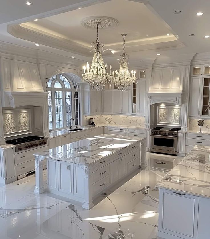 a large kitchen with marble counter tops and white cabinets, chandelier hanging from the ceiling