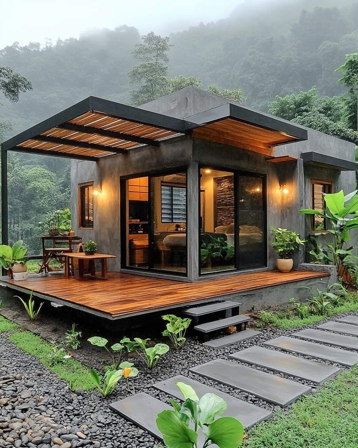 a small house in the middle of a lush green area with stairs leading up to it