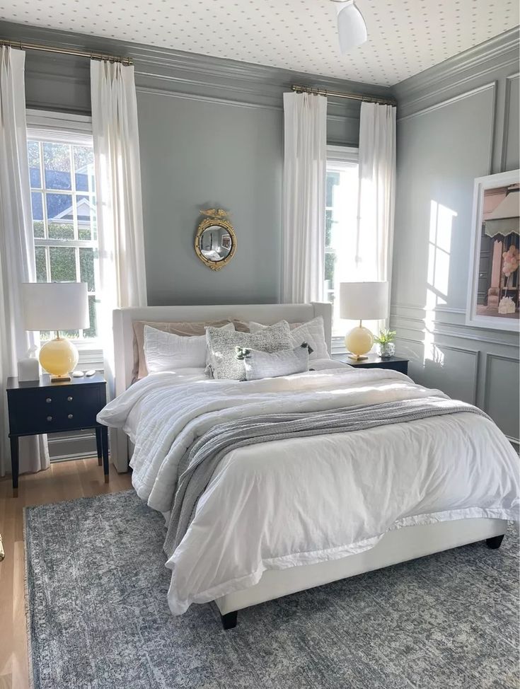 a bedroom with gray walls and white bedding