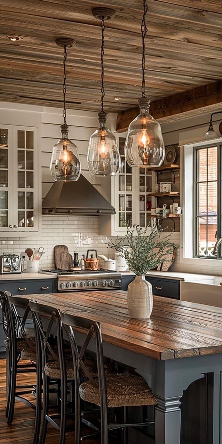 a kitchen with wooden floors and lots of lights hanging from the ceiling over the island