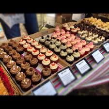 an assortment of cupcakes and pastries on display