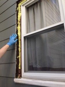 a man in blue gloves is painting the outside of a house