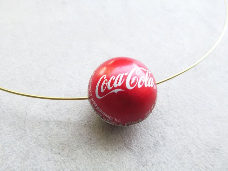 a red coca cola ball sitting on top of a white floor next to a cord