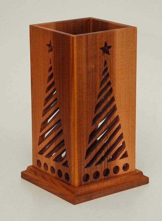 a wooden box with laser cut designs on the front and sides, sitting on a white surface