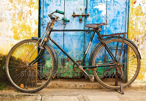 an old bicycle leaning against a blue door