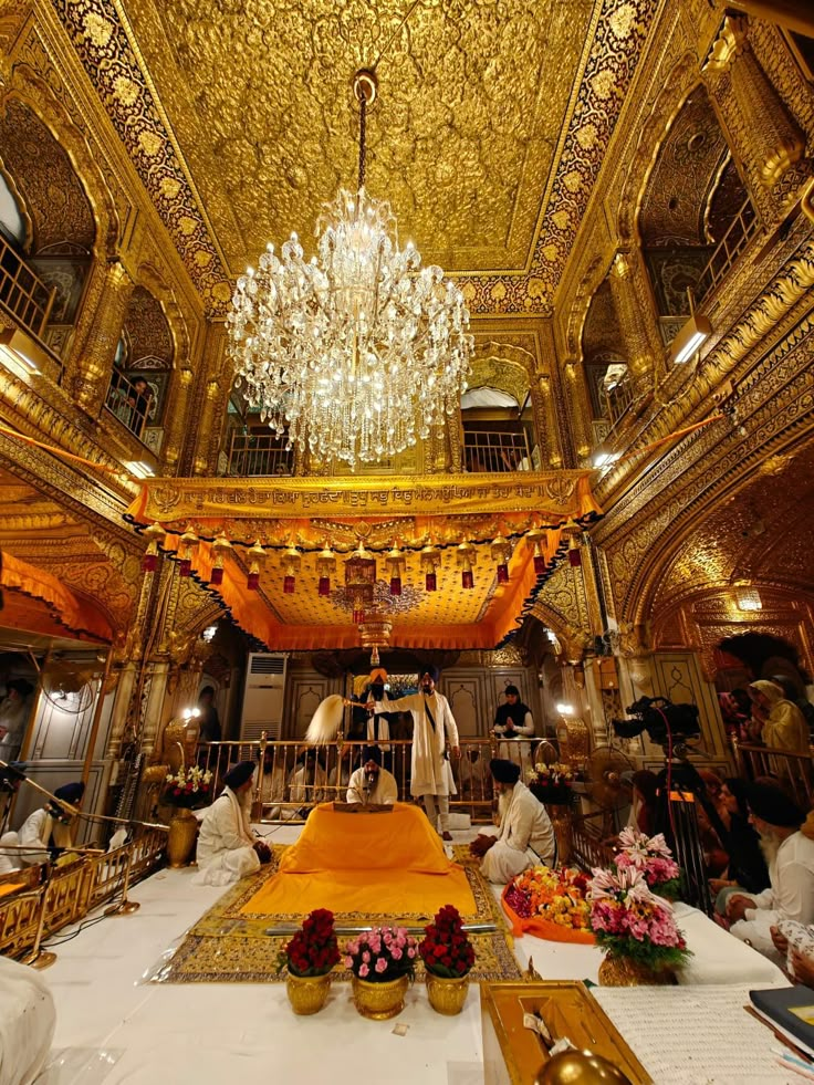 an elaborately decorated room with chandelier and flowers on the table in front of it