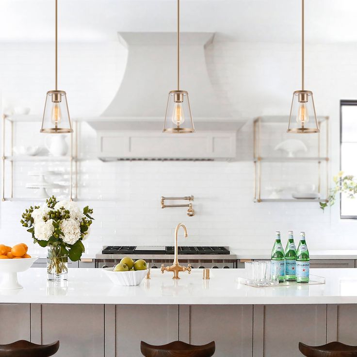 a kitchen island with four stools in front of it and bottles on the counter