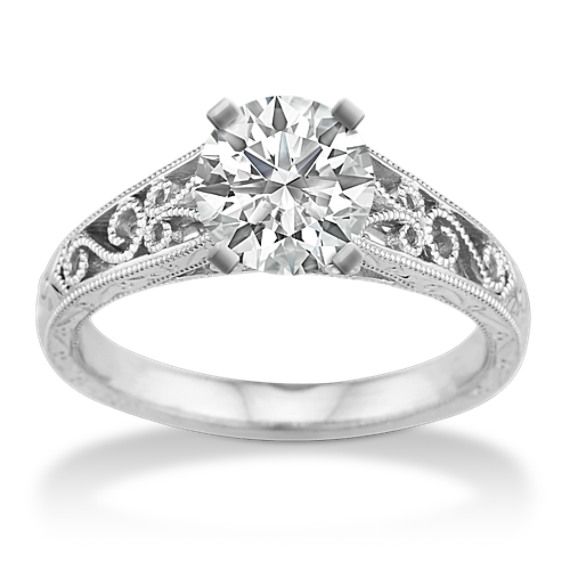 a diamond engagement ring with filigrees on the sides